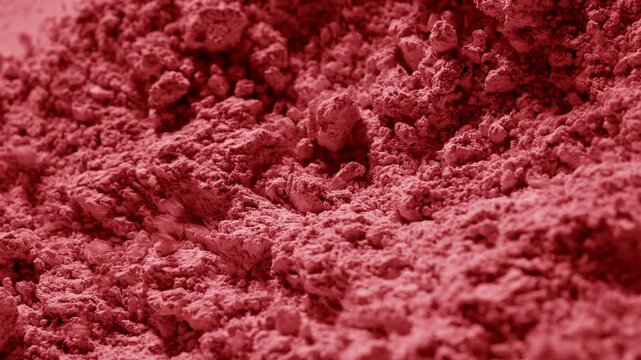 Tight macro slow-motion shot of red airflow disturbing powder surface, sending particles and clumps outward | Concept for a blush advertisement