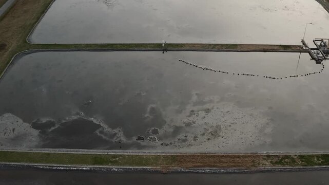 Wastewater treatment basin with polluted sewage, water pollution and industrial environmental contamination, aerial view.