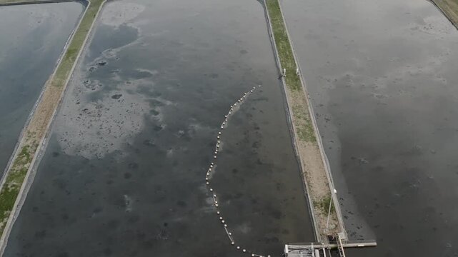 Sewage treatment lagoon and wastewater basin with sludge aeration, sanitation management and pollution, aerial view.