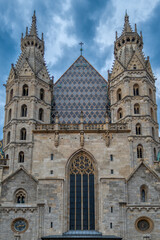 Obraz premium Symmetrical view of the historic west facade and towers of St. Stephen's Cathedral under cloudy sky in Vienna