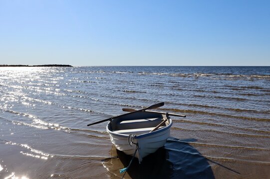 peaceful summer morning at the beach with a lonely boat by the water
