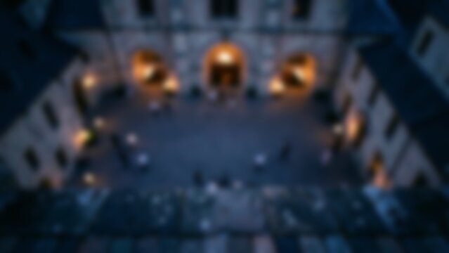 moody blurred evening courtyard with warm glowing arches for website