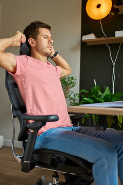 Man adjusting headrest on ergonomic office chair