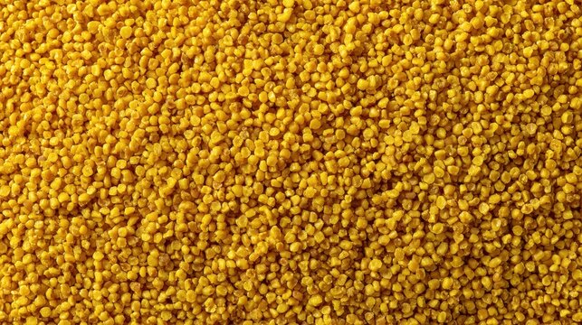 Close-up of yellow millet grains in a heap with detailed texture and vibrant color