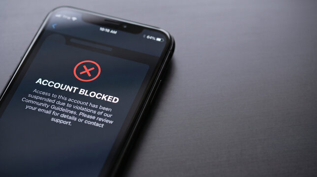 Smartphone screen showing account blocked due to policy violations