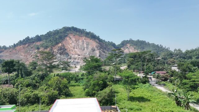 Scenic view of a lush green landscape with a rocky mountain slope in the background.