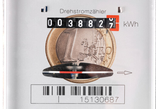 Eine Eurom&uuml;nze ist auf einem Stromz&auml;hler &uuml;berblendet, als Symbolbild f&uuml;r Hohe Stromkosten und Energieverbrauch - FOTOMONTAGE