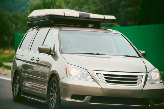 Traveling car with roof tent on countryside road highway