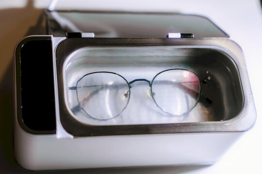 Eyeglasses cleaning process in water-filled device