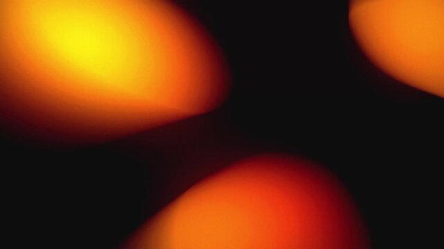 Abstract light leaks texture with yellow and orange glow. Dynamic lens flare overlay for creative video editing. Cinematic transition effect on dark background.