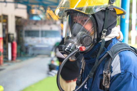 Portrait brave firefighter wearing oxygen mask and SCBA equipment, getting ready to respond to an emergency call