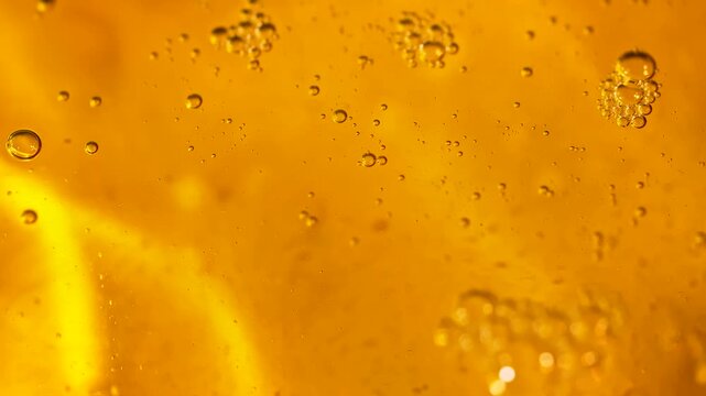 Golden sunflower oil contains suspended bubbles in a luminous macro view. Concept food advertising, cooking brands, packaging, banners and abstract design.