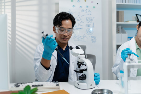 Scientists perform laboratory experiments using microscopes, pipettes and test tubes while analyzing samples in modern research laboratory, representing biotechnology, diagnostics and medical science.
