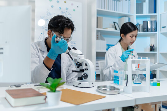 Scientists perform laboratory experiments using microscopes, pipettes and test tubes while analyzing samples in modern research laboratory, representing biotechnology, diagnostics and medical science.