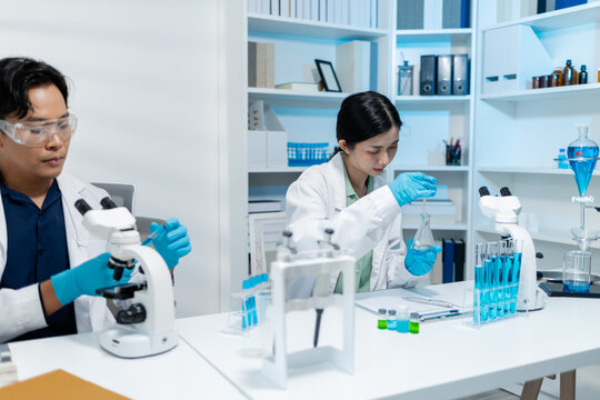 Scientists perform laboratory research using microscopes, test tubes, and modern scientific equipment to analyze samples, representing biotechnology, healthcare, diagnostics, and medical innovation.