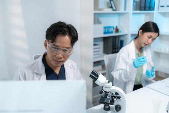 Scientists perform laboratory research using microscopes, test tubes, and modern scientific equipment to analyze samples, representing biotechnology, healthcare, diagnostics, and medical innovation.