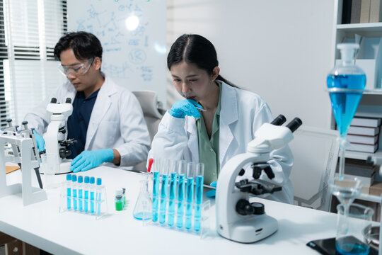 Scientists perform laboratory research using microscopes, test tubes, and modern scientific equipment to analyze samples, representing biotechnology, healthcare, diagnostics, and medical innovation.