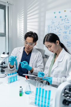 Scientists perform laboratory experiments using microscopes, pipettes and test tubes while analyzing samples in modern research laboratory, representing biotechnology, diagnostics and medical science.