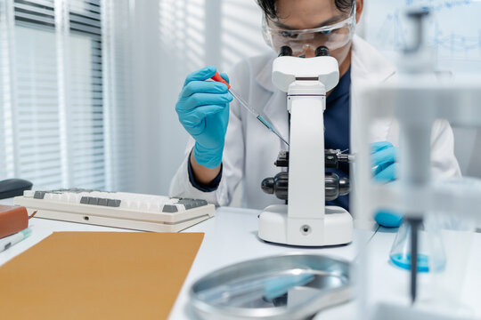 Scientists perform laboratory experiments using microscopes, pipettes and test tubes while analyzing samples in modern research laboratory, representing biotechnology, diagnostics and medical science.