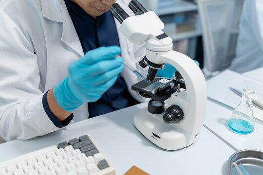Scientists perform laboratory experiments using microscopes, pipettes and test tubes while analyzing samples in modern research laboratory, representing biotechnology, diagnostics and medical science.