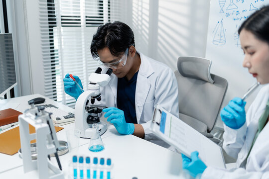 Scientists analyze liquid samples using test tubes, microscopes, and laboratory equipment, representing biotechnology, medical diagnostics, research, and healthcare innovation.