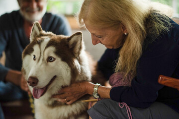 Elderly woman petting husky dog. © Rawpixel.com