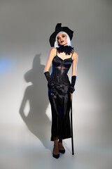 Obraz premium Glamorous witch in a stunning costume poses playfully in the studio