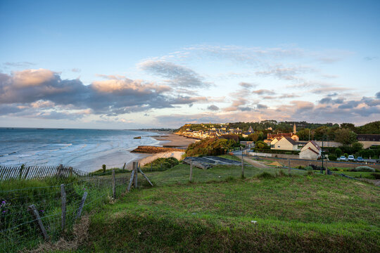 Panoramic view of Gold Beach in Arromanches les Bains Normandy France with World War II mulberry harbor remains at sunset