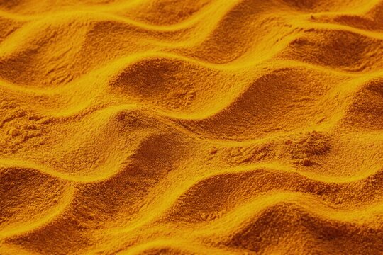 Turmeric powder forming wavy patterns, showcasing vibrant color and texture in a culinary setting