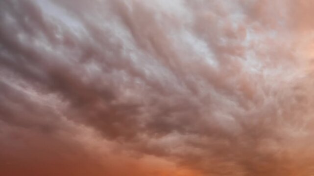 Dramatic undulatus asperitas storm clouds moving fast at orange sunset