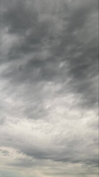 Vertical timelapse of dramatic undulatus storm clouds moving fast in grey sky