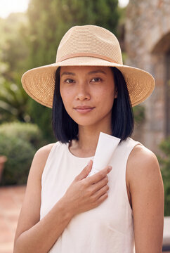 Woman in a straw hat holding a sunscreen tube for sun protection portrait and skincare product banner