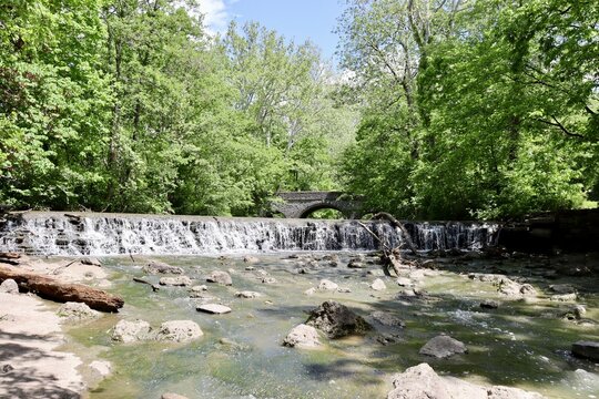The waterfall in the woods on a sunny day.