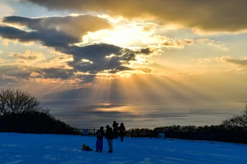 Winter landscape of Hakodate mountain viewpoint with tourists watching dramatic sunset over sea © I Viewfinder