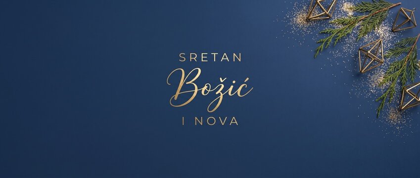 Christmas background blue gold typography with Sretan Bozic greeting text, featuring pine branches, geometric ornaments, glitter dust, minimalist design, and copy space for holiday greeting card.