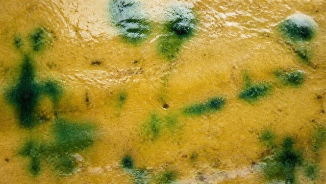 黄瀬戸のテクスチャ 黄色い釉に緑の胆礬が滲む陶器の面