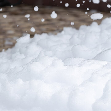 Soft snowflakes fall gently onto a fresh, textured pile