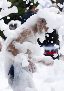 Person covered in white foam, mid-motion