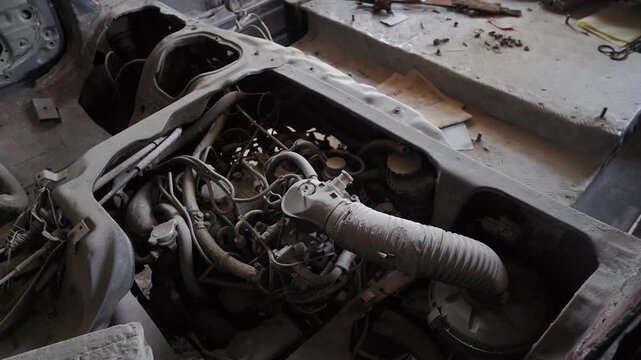 Disassembled vehicle chassis with exposed engine in repair shop car automotive