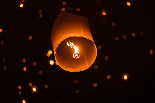 Sky lantern floating in the dark night sky, Tourist floating sky lanterns, Sky lanterns floating on night of Yi Peng, Loy Krathong Festival or Yi Peng Festival in Chiang Mai Thailand.