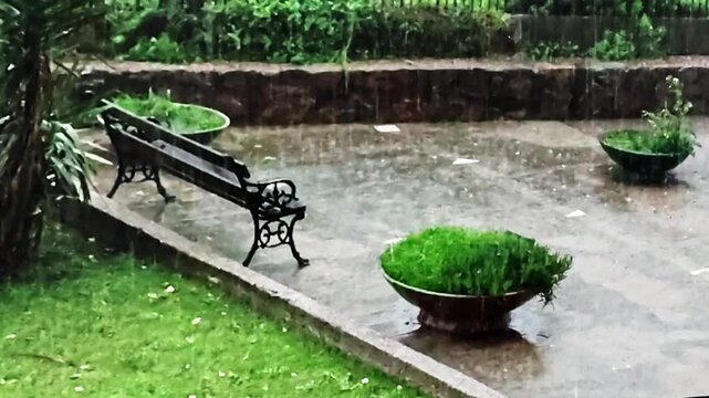 Long fixed shot of an empty urban park sector on a rainy day. 