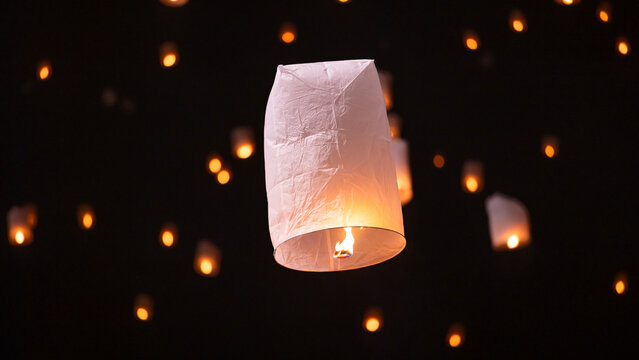 Sky lantern floating in the dark night sky, Tourist floating sky lanterns, Sky lanterns floating on night of Yi Peng, Loy Krathong Festival or Yi Peng Festival in Chiang Mai Thailand.