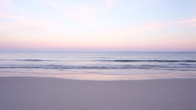 A peaceful sunset view over the calm ocean and sandy beach