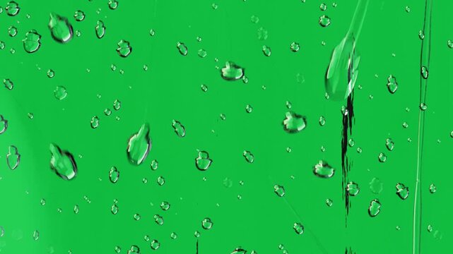 Droplets on glass panel with clear background responding to gravity, merging, elongating, sliding