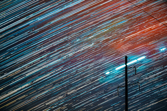 Unusual Amazing Effects In Sky. Bright Night Starry Sky Background. Trails Of Stars Rotate Above Power Line. Large Exposure. Imagination, Fantasy, Illusion, Dream View. Flight Of Fancy