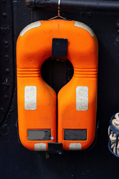 Orange Lifebuoy Hanging on Ship Wall
