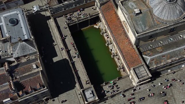 Tourists walking around the historic roman baths in Bath, Somerset. Aerial Drone Shot.