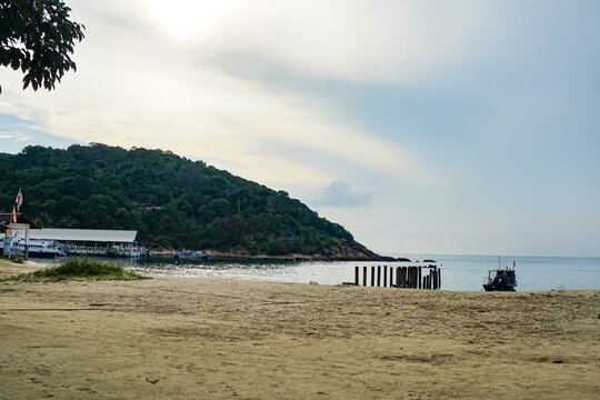 Sandy Beach With Hill And Pier Remains