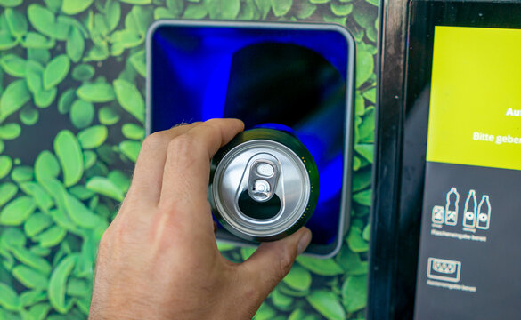 Returning Empty Bottles and Cans at a Supermarket Recycling Machine &ndash; Deposit Return, Recycling and Sustainability Concept