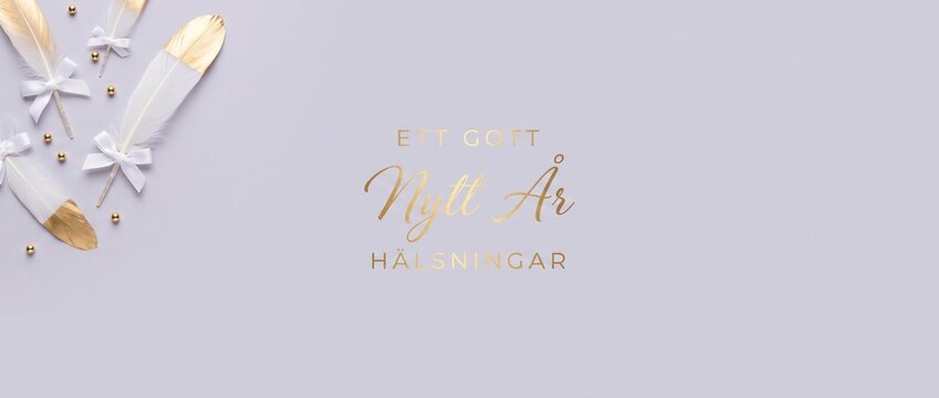 Swedish Happy New Year greeting with gold text Ett Gott Nytt Ar Halsningar on pastel background decorated with white feathers ribbons and golden beads for festive celebration card design copy space